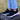 A woman in black and white Explorer V2 hemp shoes for women, stands on an old tree stump.