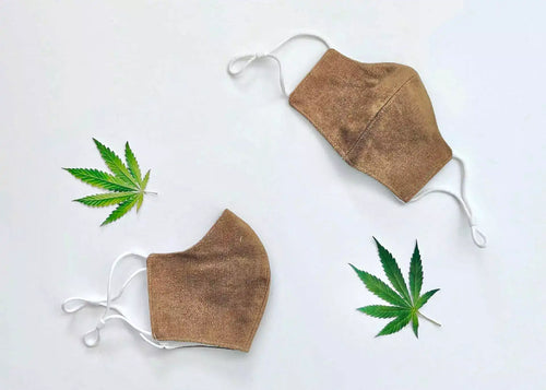 Two anti-bacterial hemp masks on a white surface.